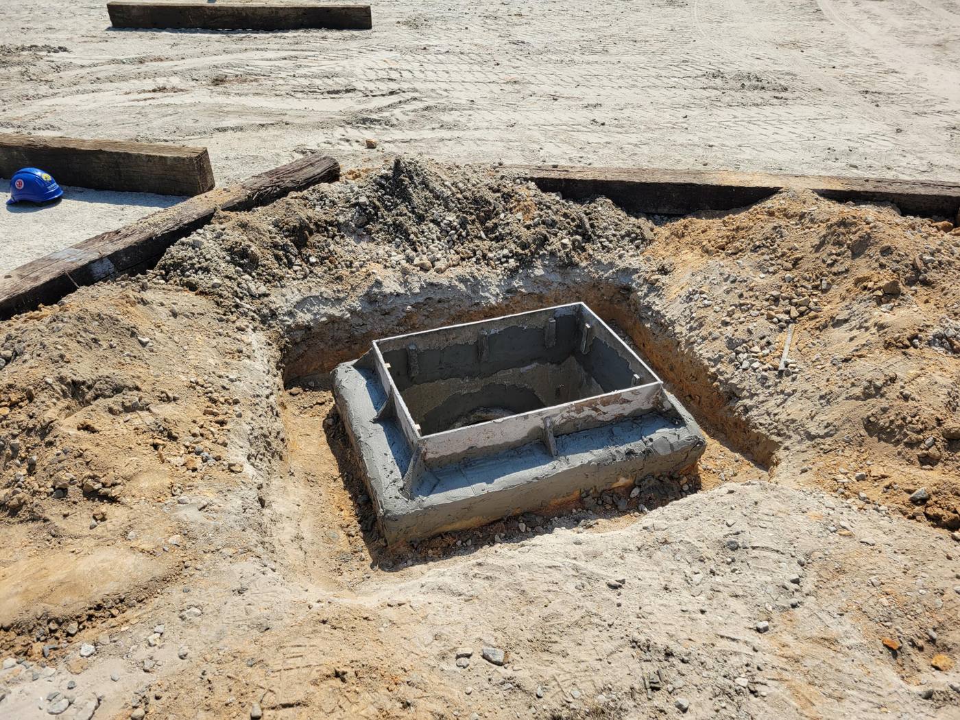 Concrete catch basin set in an excavated hole